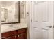 Bathroom featuring a vanity with a wood cabinet, a large mirror, towel rack, and a door, maximizing space and convenience at 2028 S Esmeralda --, Mesa, AZ 85209