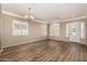 Spacious living room with wood-look floors, large windows, and elegant chandelier at 2028 S Esmeralda --, Mesa, AZ 85209