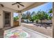 Inviting covered patio with a ceiling fan, a view of the pool, and lush greenery, offering a relaxing outdoor space at 2028 S Esmeralda --, Mesa, AZ 85209