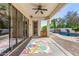 Inviting covered patio with a ceiling fan, sliding glass doors, a view of the pool, and lush greenery, offering a relaxing space at 2028 S Esmeralda --, Mesa, AZ 85209