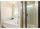 Modern bathroom with a glass-doored shower, a bathtub, and natural light at 213 E Vaughn Ave, Gilbert, AZ 85234