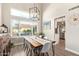 Open dining room featuring a wood table, modern chairs, and large windows with bright natural light at 213 E Vaughn Ave, Gilbert, AZ 85234