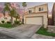 Charming two-story home with a two car garage, lush landscaping, and a lovely red umbrella on the front patio at 213 E Vaughn Ave, Gilbert, AZ 85234