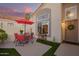 Cozy front porch with red umbrella, stylish seating, and a beautiful front door with a wreath at 213 E Vaughn Ave, Gilbert, AZ 85234