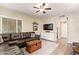 Comfortable living room featuring a plush sectional sofa, wood-look flooring, and natural light from multiple windows at 213 E Vaughn Ave, Gilbert, AZ 85234