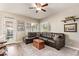 Comfortable living room featuring a plush sectional sofa, wood-look flooring, and natural light from multiple windows at 213 E Vaughn Ave, Gilbert, AZ 85234