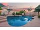 Gorgeous backyard pool with waterfall feature, blue tile detail, lounge chairs, and privacy landscaping at 213 E Vaughn Ave, Gilbert, AZ 85234