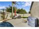 Patio with fire pit, unique concrete bench, grill, and landscaped greenery at 21616 N 82Nd Ln, Peoria, AZ 85382