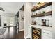 A contemporary bar area with a wine refrigerator, floating shelves, and marble countertop at 21616 N 82Nd Ln, Peoria, AZ 85382