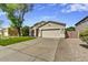 A well-maintained single story home with a lush green lawn, desert landscaping, and wide driveway at 21616 N 82Nd Ln, Peoria, AZ 85382
