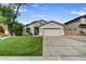 Beautiful single-story home with green lawn, desert landscaping, and a two-car garage at 21616 N 82Nd Ln, Peoria, AZ 85382