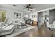 Bright living room featuring hardwood floors, neutral paint, a modern ceiling fan, and elegant furniture at 21616 N 82Nd Ln, Peoria, AZ 85382