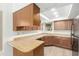 Functional kitchen with wood cabinets, laminate countertops, and sufficient counter space for meal preparation at 2455 E Broadway Rd # 39, Mesa, AZ 85204