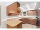 Functional kitchen with wood cabinets, laminate countertops, and neutral paint at 2455 E Broadway Rd # 39, Mesa, AZ 85204