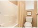 Well-lit bathroom featuring a bathtub with shower and tiled walls at 2674 N Saide Ln, Buckeye, AZ 85396