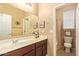 Bright bathroom featuring a large mirror, vanity, and a separate toilet and shower area at 2674 N Saide Ln, Buckeye, AZ 85396