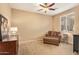Comfortable bedroom with carpeted floors, soft natural light, and cozy sitting chair at 2674 N Saide Ln, Buckeye, AZ 85396