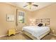 Comfortable bedroom featuring a cozy bed with a decorative headboard and a sunny window view at 2674 N Saide Ln, Buckeye, AZ 85396