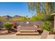 Relaxing backyard hot tub with custom stone surround, nestled amid lush landscaping and serene mountain views at 2674 N Saide Ln, Buckeye, AZ 85396