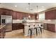 Modern kitchen boasts an island with seating, stainless appliances, and tiled backsplash at 2674 N Saide Ln, Buckeye, AZ 85396