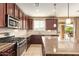 A modern kitchen with stainless steel appliances, granite countertops, and access to the backyard patio at 2674 N Saide Ln, Buckeye, AZ 85396
