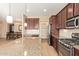 A kitchen with stainless steel appliances, granite countertops, and a view of the dining room and pantry at 2674 N Saide Ln, Buckeye, AZ 85396