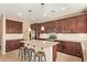 Beautiful kitchen with dark wood cabinets, granite countertops, and an island with barstools at 2674 N Saide Ln, Buckeye, AZ 85396