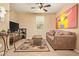 Cozy living room features a comfortable sofa, stylish rug, ceiling fan, and unique wall decor at 2674 N Saide Ln, Buckeye, AZ 85396