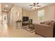 Neutral-toned living room featuring tile flooring, a comfortable sofa, and unique wall decor at 2674 N Saide Ln, Buckeye, AZ 85396