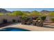 Inviting backyard patio with comfortable outdoor seating, surrounded by lush landscaping and stunning mountain views at 2674 N Saide Ln, Buckeye, AZ 85396