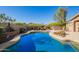 Inviting backyard pool with elegant stone surround and comfortable seating area, perfect for outdoor entertaining at 2674 N Saide Ln, Buckeye, AZ 85396