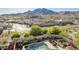Inviting backyard oasis featuring a sparkling pool, lush landscaping, and stunning mountain views at 2674 N Saide Ln, Buckeye, AZ 85396