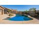 Sparkling pool with uniquely shaped design complemented by lush desert landscaping and a spacious patio at 2674 N Saide Ln, Buckeye, AZ 85396