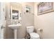 Cozy powder room with a pedestal sink, toilet, and decorative mirror at 280 S Evergreen Rd # 1320, Tempe, AZ 85288