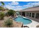 Lush backyard with a pool, rock waterfall, and patio area perfect for outdoor relaxation and entertainment at 28019 N 115 Pl, Scottsdale, AZ 85262