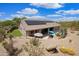 Aerial view of home featuring a pool, solar panels, desert landscaping, and outdoor seating at 28019 N 115 Pl, Scottsdale, AZ 85262