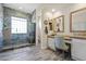Modern bathroom with tile floors, glass shower, and a vanity area with chair and dual mirrors at 28019 N 115 Pl, Scottsdale, AZ 85262