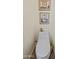 Toilet in a bathroom with decorative wall art and basic supplies at 28019 N 115 Pl, Scottsdale, AZ 85262
