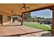 Expansive covered back patio with ceiling fans overlooks a beautifully landscaped yard and a pool area at 2918 N 90Th St, Mesa, AZ 85207
