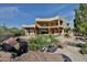 Multi-story home with balconies overlooking a landscaped yard with pool and rock features at 2918 N 90Th St, Mesa, AZ 85207