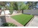 A backyard features well-maintained artificial turf, a lush landscape, and a serene atmosphere at 3371 W Grandview Rd, Phoenix, AZ 85053