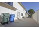 View of backyard featuring white siding, a privacy wall, and trash and recycle cans on a concrete patio at 3371 W Grandview Rd, Phoenix, AZ 85053
