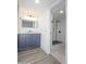 Modern bathroom vanity next to shower with black fixtures and white tile at 3371 W Grandview Rd, Phoenix, AZ 85053