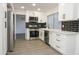 Bright kitchen featuring stainless appliances, white cabinets, and a black subway tile backsplash at 3371 W Grandview Rd, Phoenix, AZ 85053