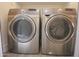 Modern laundry room with front-loading Samsung washer and dryer in silver color at 3371 W Grandview Rd, Phoenix, AZ 85053