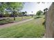 View of a shady neighborhood park with green grass, a walking path, and trees under a clear blue sky at 3371 W Grandview Rd, Phoenix, AZ 85053