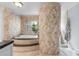 Large bathroom features jacuzzi tub, tiled walls, and a unique tiled column at 3411 E Sells Dr, Phoenix, AZ 85018