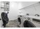 Well-equipped laundry room with modern appliances and shelving, designed for efficient organization at 35616 N 34Th Ln, Phoenix, AZ 85086