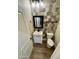Compact powder room features patterned wall tile, wood look flooring and a white vanity at 41143 W Rio Bravo Dr, Maricopa, AZ 85138