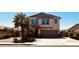 Two-story tan house featuring a two-car garage, desert landscaping, and palm trees at 41143 W Rio Bravo Dr, Maricopa, AZ 85138